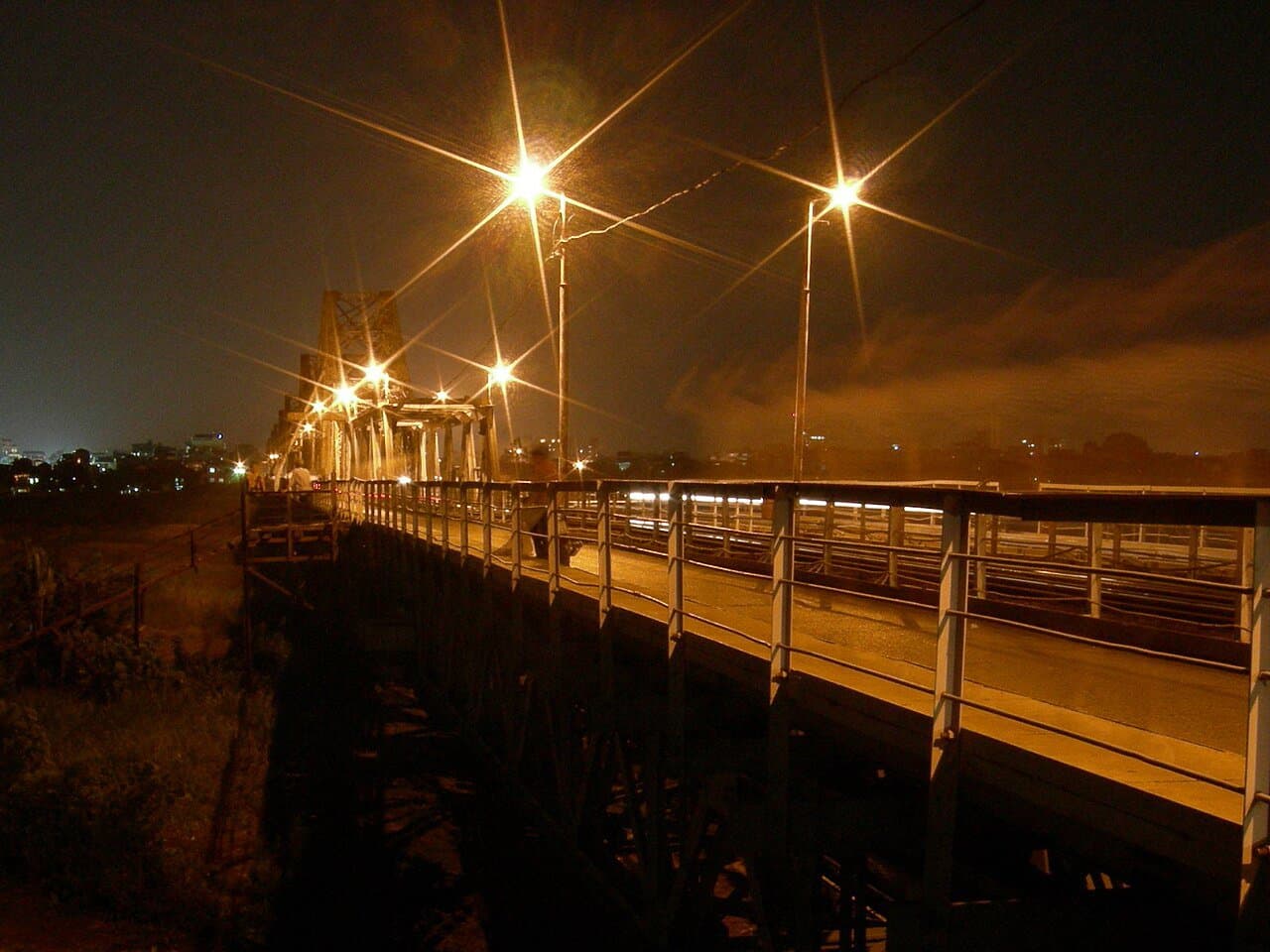 Long Bien bridge lit against the night sky over Hanoi's Red River — October's cool, dry autumn evenings are when the capital, and the north, are at their best