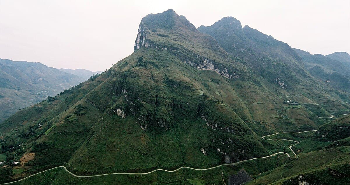 The winding road of Ma Pi Leng Pass through limestone mountains in Ha Giang