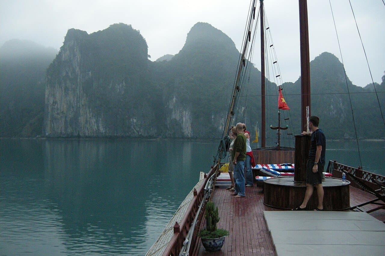 The deck of a Ha Long Bay cruise overlooking the karst islands at sunset — the standard mid-range cruise vantage point