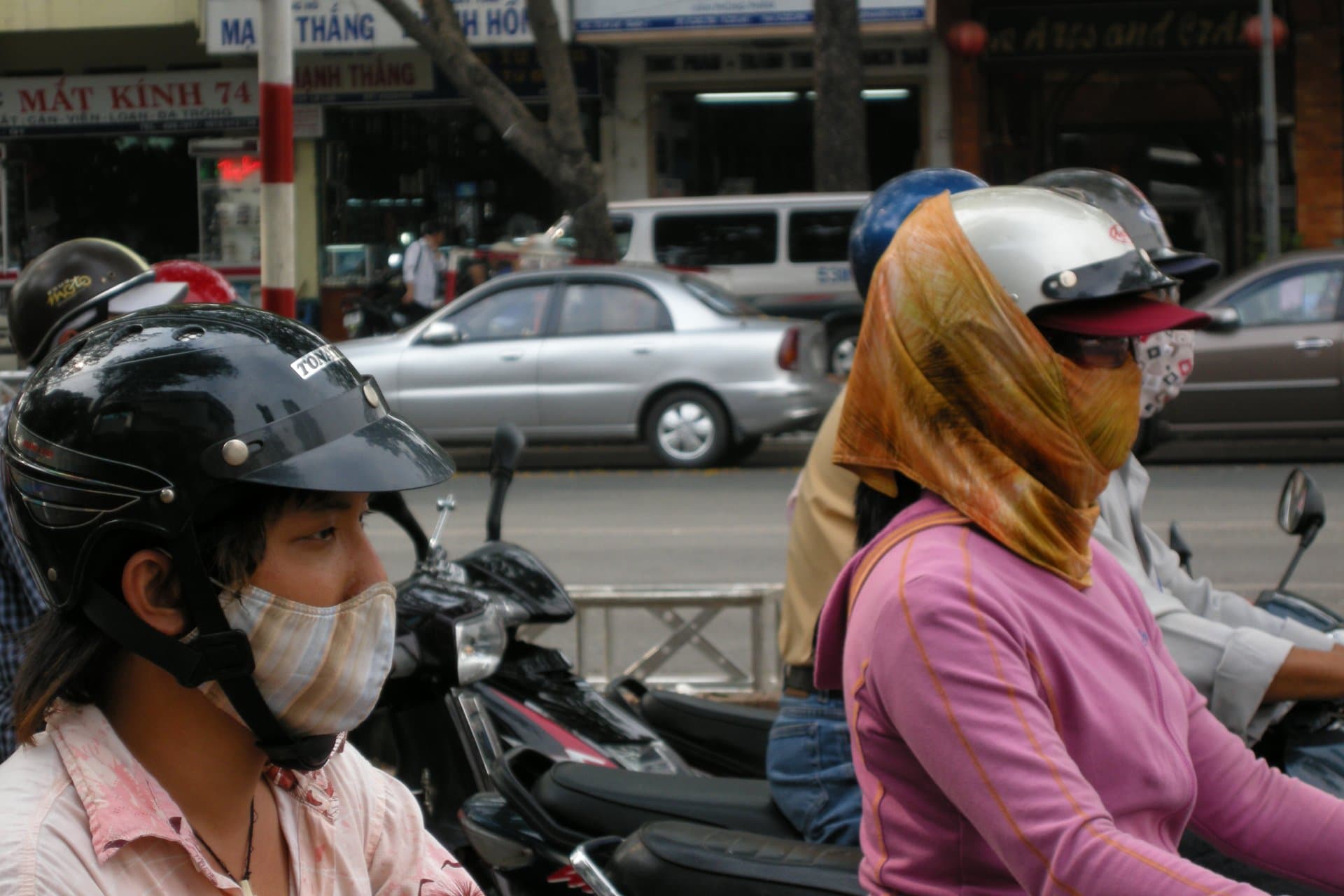 Helmet-wearing motorbike riders in HCMC traffic — the everyday context where scam scenarios arise