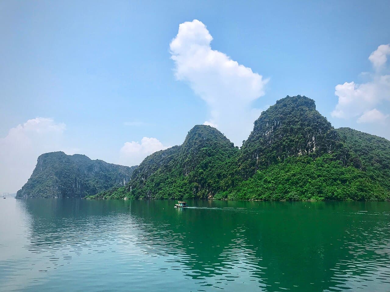 Limestone karsts rising from the turquoise water of Ha Long Bay at dawn