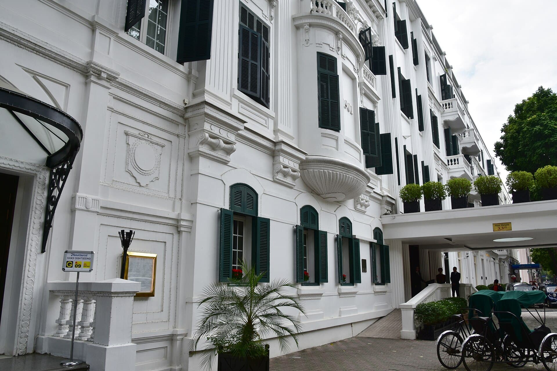 The Sofitel Legend Metropole Hanoi's iconic French colonial facade with the signature green-shuttered windows and cyclos out front — Vietnam's most-photographed luxury hotel entrance