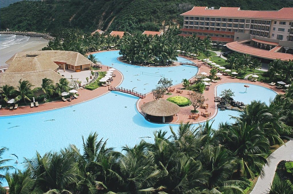 Aerial view of a Vietnamese beach resort with palm-lined infinity pools