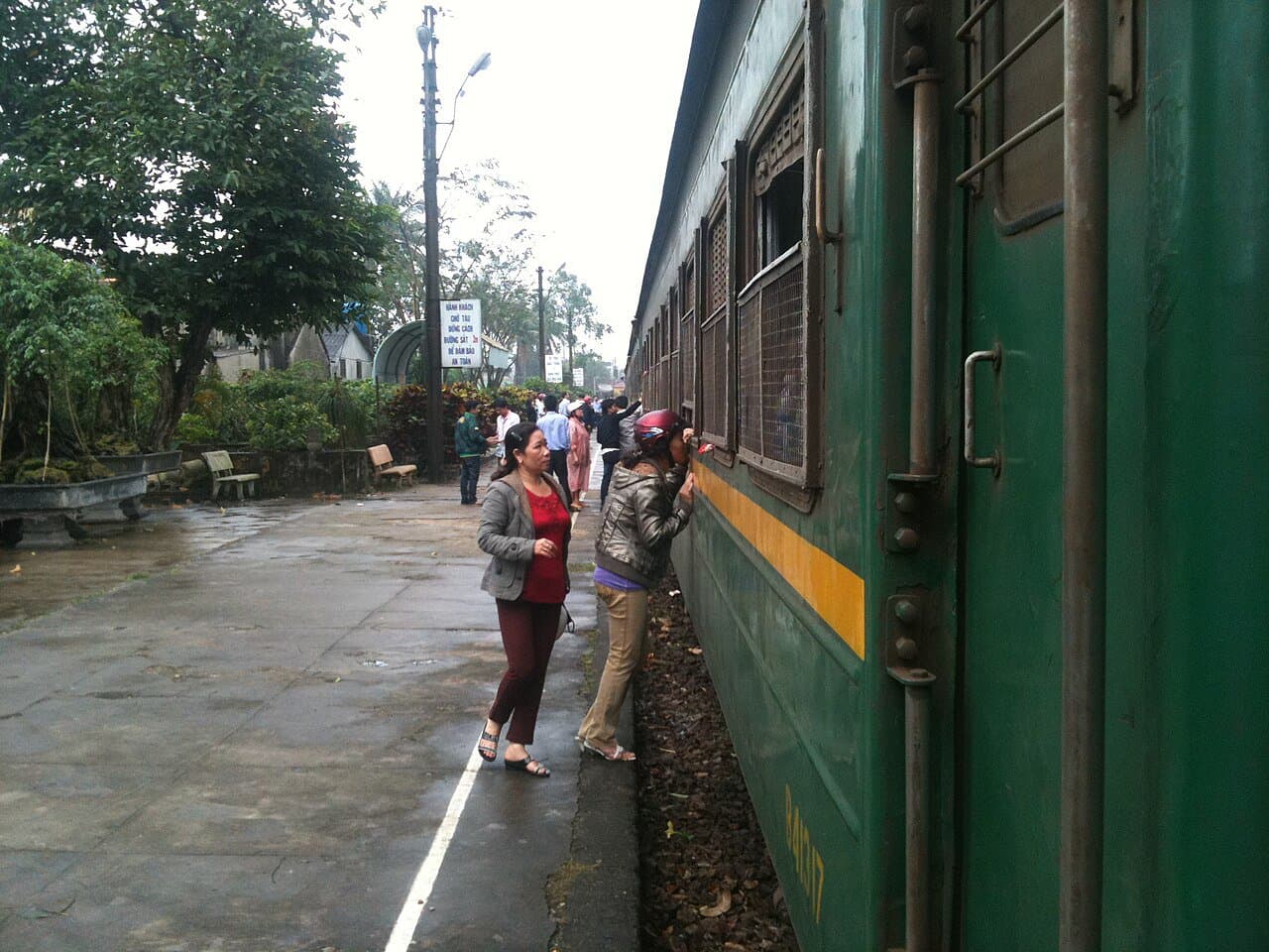 A backpacker boarding a Vietnam Railways train at a regional station — the budget transport spine of any first solo trip
